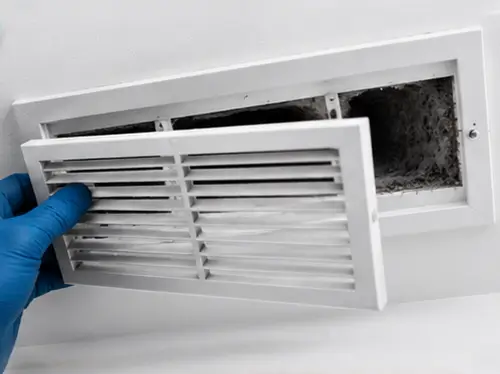 Technician cleaning residential air vent